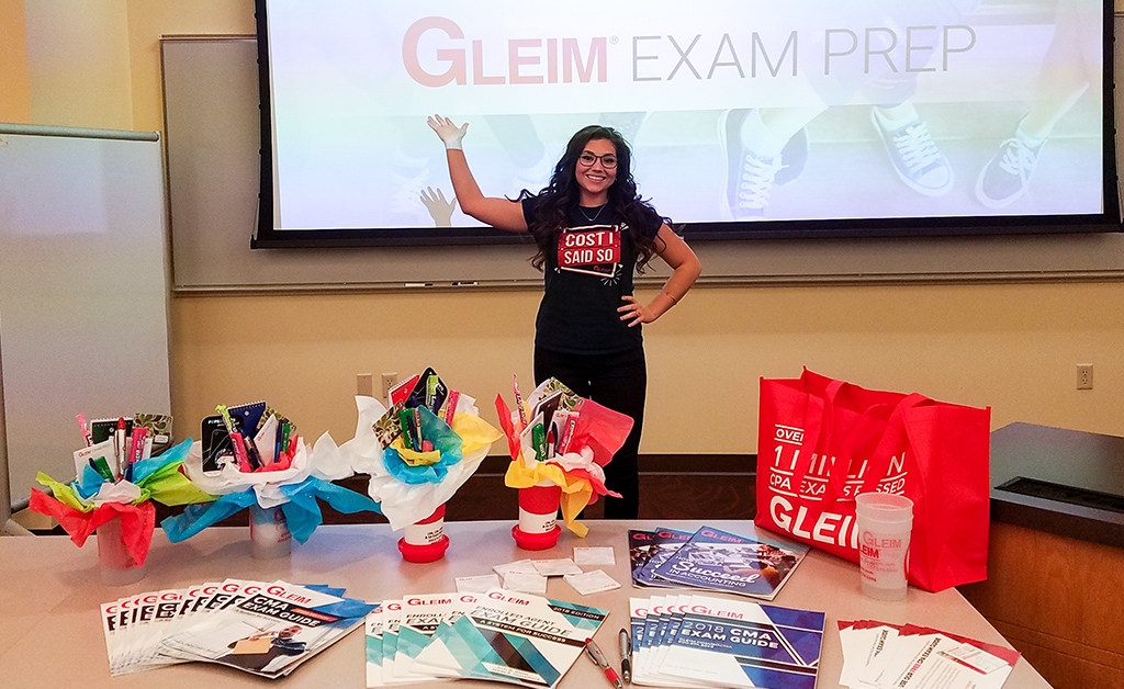 Braylee standing in front of a projector screen and giving a presentation on Gleim at an accounting club meeting at Colorado Mesa University